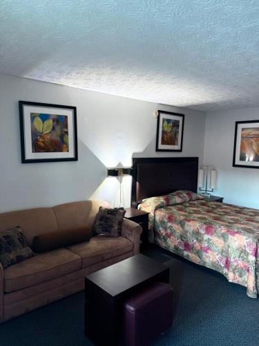 a hotel room with a bed and a couch at Auberge Canadienne in Temiscaming