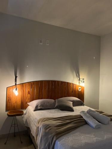 a bedroom with a large bed with a wooden headboard at Hotel Fazenda Vitoria in Pindorama