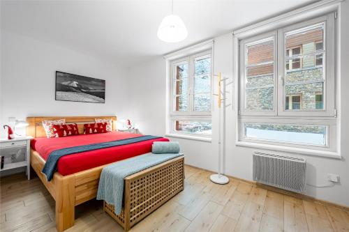 a bedroom with a large bed and two windows at Horní Mísečky - I3 Pohodlný a teplý apartmán u sjezdovky in Horni Misecky