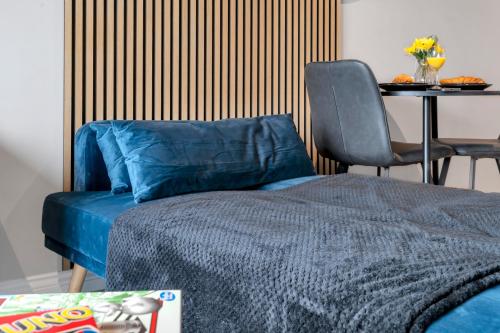 ein Schlafzimmer mit einem Bett und einem Tisch mit einem Stuhl in der Unterkunft The Noir Suite - City Centre in Beeston Hill