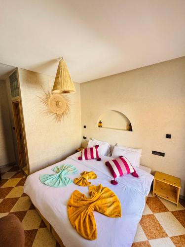 a bedroom with a large white bed with pillows at Natural Surf Morocco in Tamraght Ouzdar