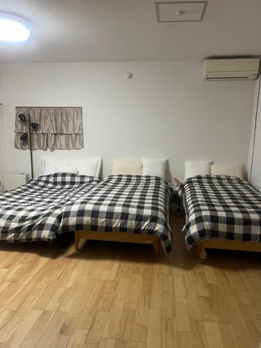 two beds sitting next to each other in a room at 8108 yadoya in Ogori