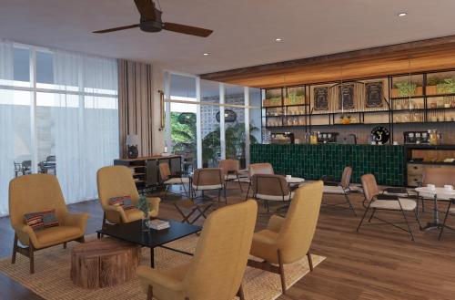 ein Wohnzimmer mit Stühlen, Tischen und einer Bar in der Unterkunft Faranda Collection Cartagena, a member of Radisson Individuals in Cartagena de Indias