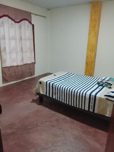 a bed sitting in a room next to a wall at Villa comoda in Puerto López