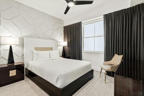 a hotel room with a bed and a chair at Villatel Orlando Resort, Apartments by Marriott Bonvoy in Orlando