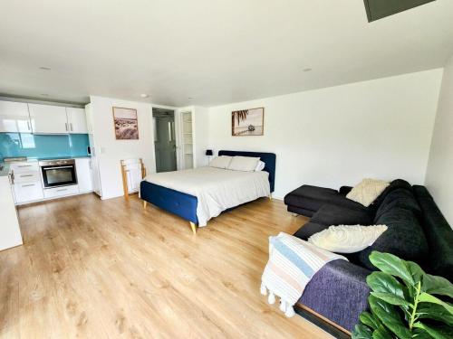 una sala de estar con un sofá y una cama en Cozy Getaway with private backyard, en Penrith