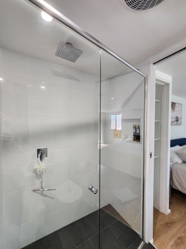a glass shower in a bathroom with a bed at Quiet Peaceful Getaway with private backyard in Penrith
