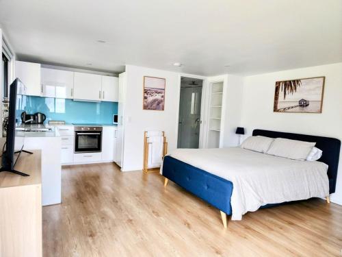 Un dormitorio con una cama grande y una cocina. en Cozy Getaway with private backyard, en Penrith
