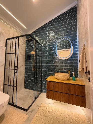 een badkamer met een douche en een blauwe tegelmuur bij Doğayla İç içe Lüks Villa in İznik