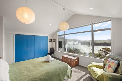 een slaapkamer met een bed en een groot raam bij Mangonui Ridge Retreat in Mangonui