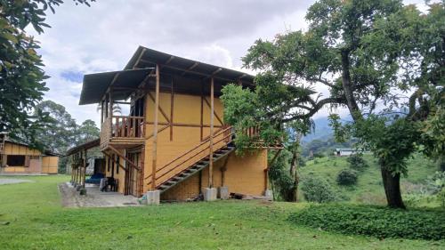 a wooden house with a wooden staircase in a field at Agüita con Limón Natural Health in Córdoba