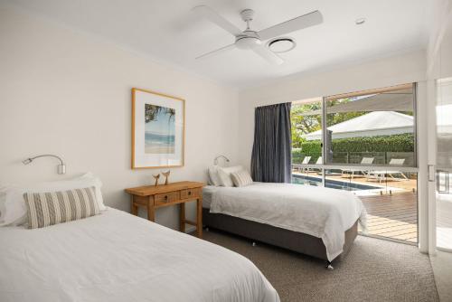 1 Schlafzimmer mit 2 Betten und einer Glasschiebetür in der Unterkunft 21 Wesley Court Noosa Sound in Noosa Heads