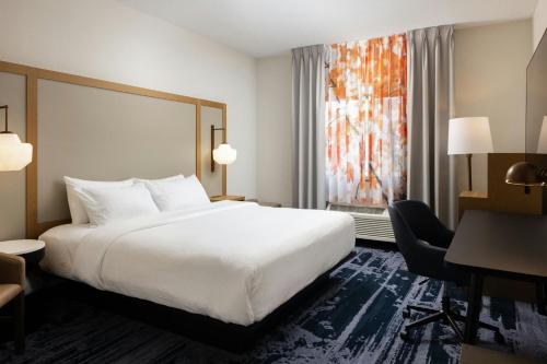 a hotel room with a bed and a desk and a window at Fairfield Inn & Suites Grand Rapids in Grand Rapids