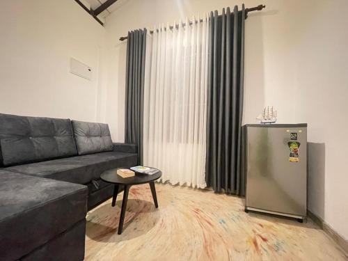 a living room with a couch and a refrigerator at Harbor Moon in Hiriketiya