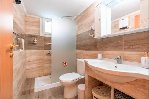 a bathroom with a white sink and a toilet at A&B Rhodes city apartments in Rhodes Town