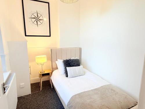 a small bedroom with a bed with a pillow on it at 4 bedrooms 8 beds Wi-FI smart tv games room in Hull