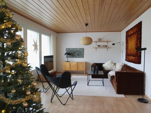 a living room with a christmas tree and a couch at Villa Vintage, Scandinavian Design and Comfort Near the City and Ski Slopes in Rovaniemi