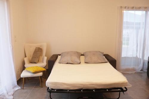a bed and a chair in a room at Relaxing, quiet, private spa, Besançon in Émagny