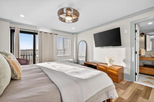 a bedroom with a large bed and a flat screen tv at Mama's Little House in Virginia Beach