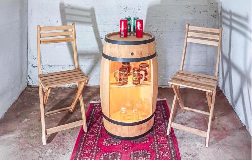 a table with two chairs and a wine barrel with bottles at 2 Bedroom Cozy Home In Kisa in Kisa