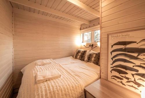 Habitación pequeña con cama en una casa de madera en Cheerful forest cabin Fireplace and Hot tub, en Akranes