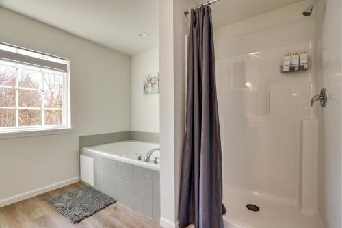 a white bathroom with a tub and a shower at Hot Tub and Lake Access Spacious Tobyhanna Home in Tobyhanna