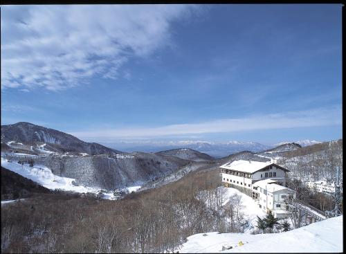a building on top of a snow covered mountain at Hotel Higashidate in Yamanouchi