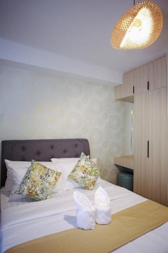 a bedroom with a white bed with two pillows at The Studio Haven in Bacolod