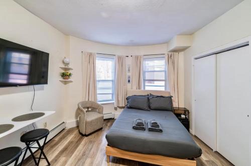 a small bedroom with a bed and a desk at Cozy Studio near MassArt & Longwood, 3-Min Walk to T in Boston
