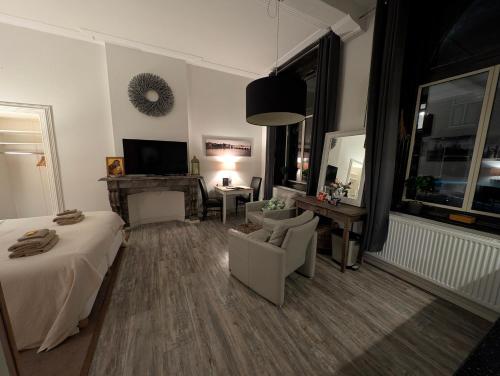 a bedroom with a bed and a chair and a television at Klooster Mariadal Maastricht in Maastricht