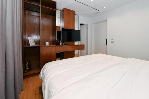 a bedroom with a white bed and a tv at Wilson On The Bllok in Tirana