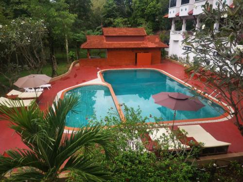 a swimming pool with umbrellas next to a building at Lifeup care and hotel in Ban Mai