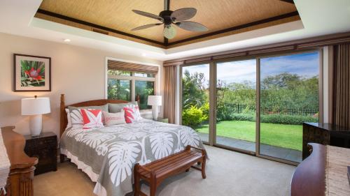ein Schlafzimmer mit einem Bett und einem Deckenventilator in der Unterkunft ENDLESS SUMMER Elegant KaMilo Home with Heated Pool and Guest Cottage in Waikoloa