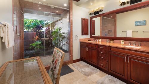 a bathroom with a table and a sink and a mirror at ❤PiH❤ Ikena Nani Ocean Coastline Views Mauna Kea Resort in Waimea