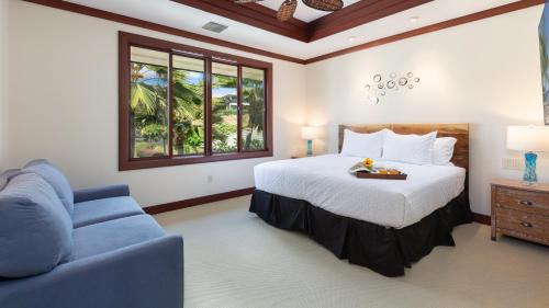 a bedroom with a bed and a blue couch at ❤PiH❤ A Sea-nic Escape Stunning Ocean View Mauna Kea Resort eBikes in Hapuna Beach