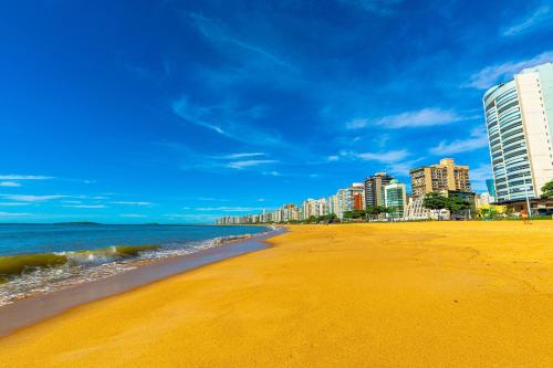Una playa con edificios altos y el océano. en 2Q Novinho! Na 2ª quadra do mar!, en Itaparica