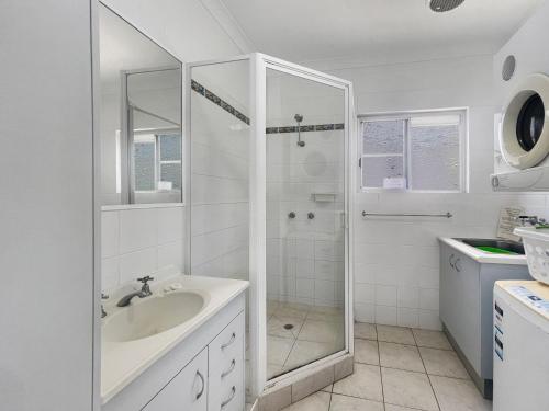 a white bathroom with a shower and a sink at Arcadia Beach Unit 4 in Arcadia