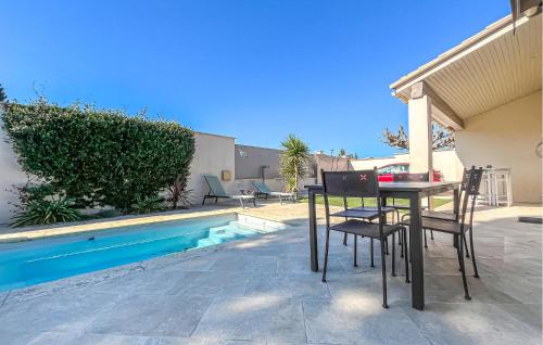 a table and chairs next to a swimming pool at Nice Home In Cabannes in Cabannes