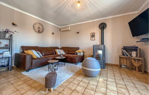 a living room with a couch and a clock on the wall at Nice Home In Cabannes in Cabannes