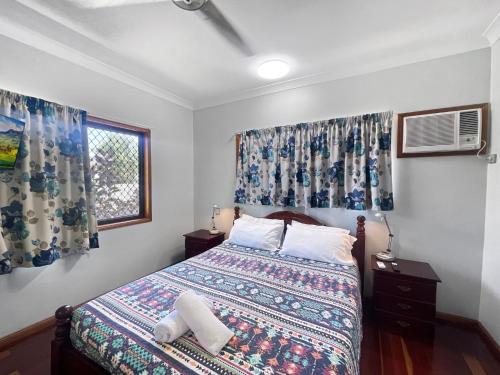 a bedroom with a bed and a window with curtains at Arcadia Gardens in Arcadia
