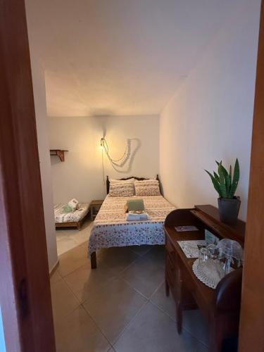 una pequeña habitación con una cama y una mesa en Vila Santíssimo Hospedagem e Café, en PatrimÃ´nio da Penha