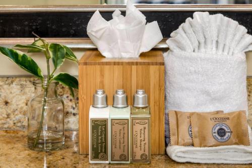 - une boîte en bois avec une bouteille de parfum et une serviette dans l'établissement 1-Bedroom Villas at Honua Kai Hokulani by KBM, à Kaanapali Airport