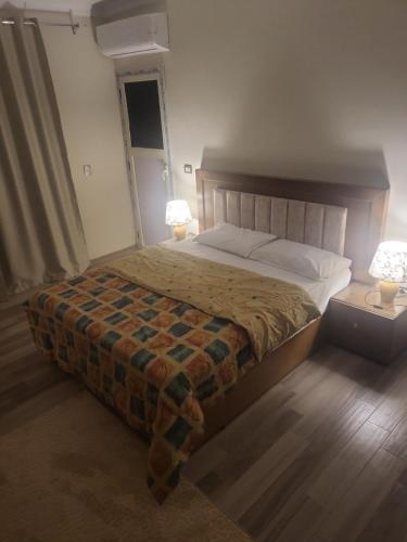 a bedroom with a large bed with two lamps at شقه إيجار wesal in Madīnat ash Shurūq