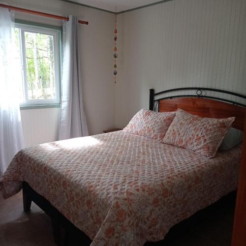 a bedroom with a bed and a window at Cabaña el Encanto in Villarrica