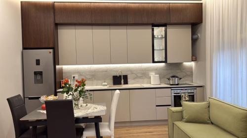 uma cozinha e sala de jantar com uma mesa e um sofá em TheCozy Home Tirana em Sauk