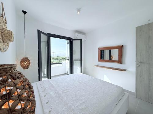 a white bedroom with a large bed and a window at Villa Finoe 4 BDR with Private Pool in Plaka