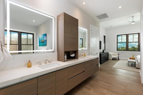 a bathroom with a large sink and a large mirror at PiH: Hale Kailani Heated Private Pool Spa in Waimea