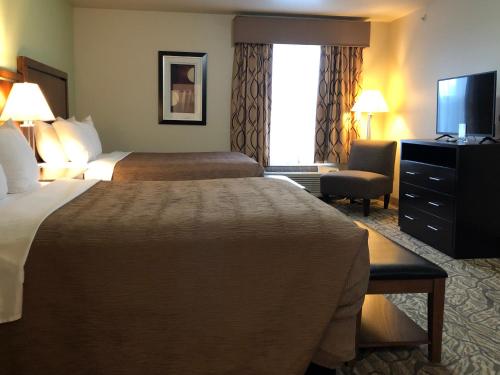 a hotel room with two beds and a television at Aspen Suites Hotel Juneau in Juneau