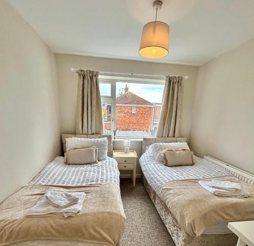 a bedroom with two beds and a window at Cosy stylish house West Hull in Hull