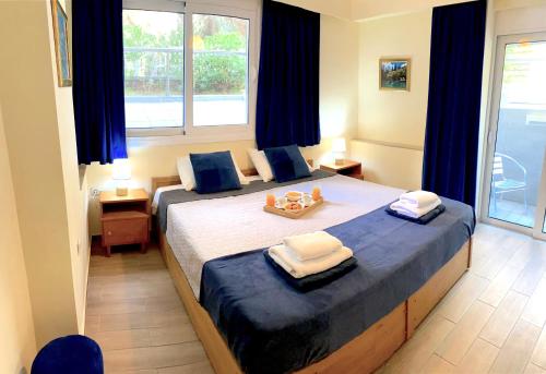 a bedroom with a large bed with blue pillows at A&B Rhodes city apartments in Rhodes Town